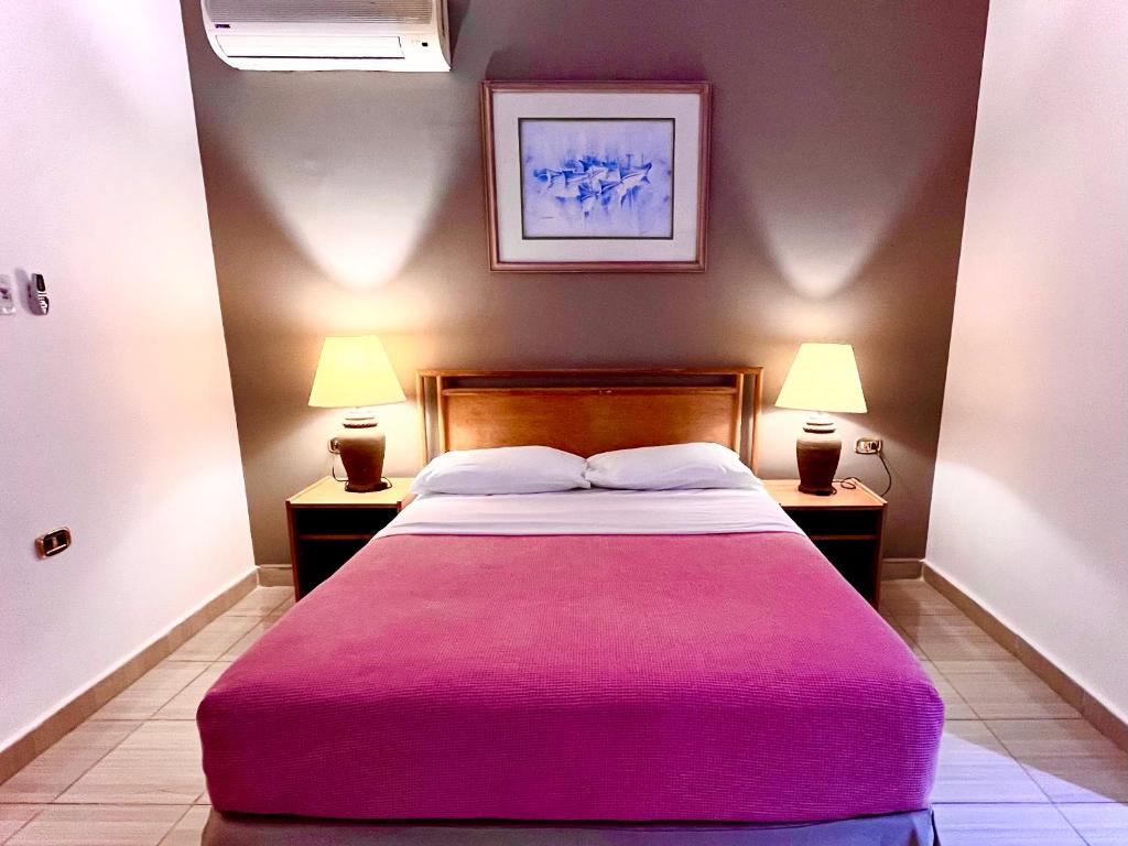 a bedroom with a large bed with a pink blanket at Masaya Hurghada in Hurghada