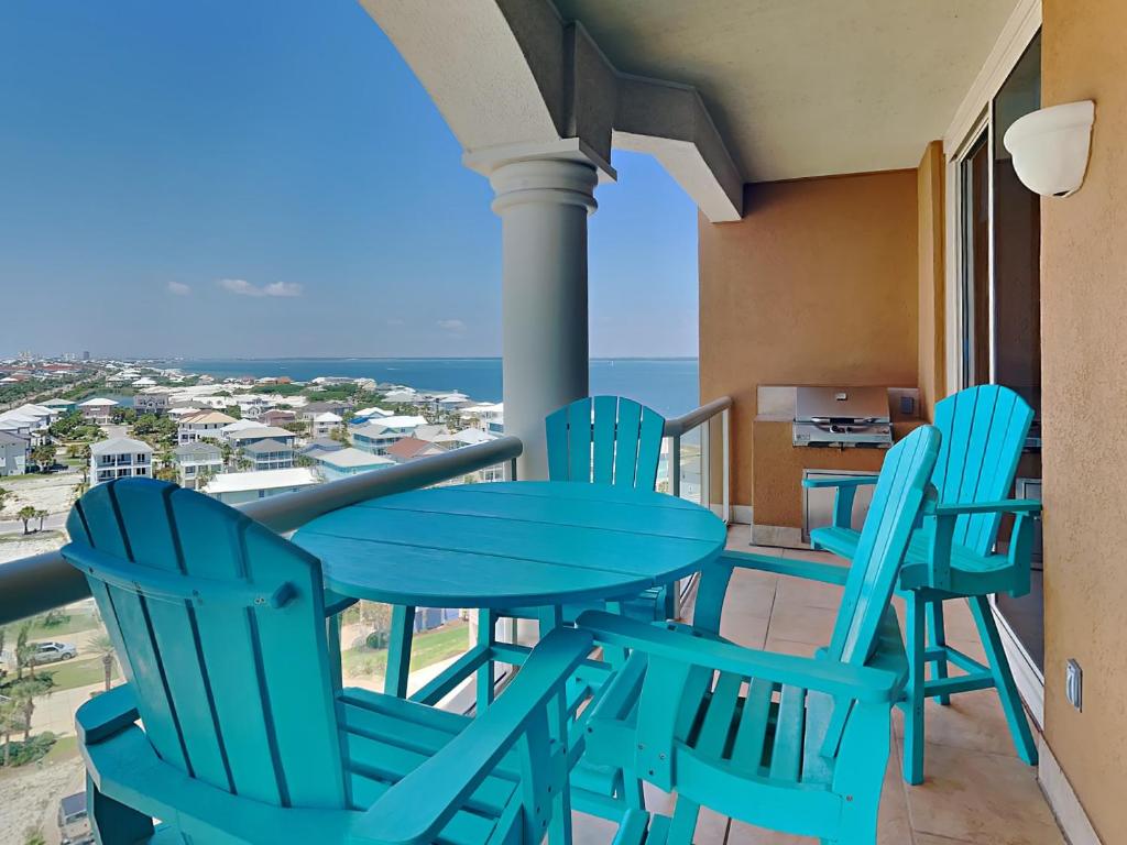 una mesa y sillas en un balcón con vistas al océano en Portofino Island Resort #5-1102, en Pensacola Beach