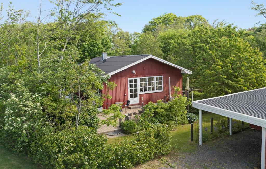 2 Bedroom Amazing Home In Thyholm في Thyholm: منزل احمر وامامه حديقه