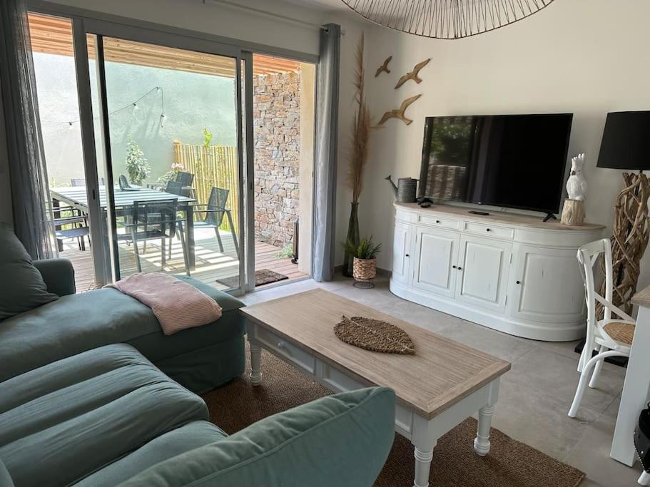 un salon avec un canapé, une télévision et une table dans l'établissement Duplex avec piscine, près de la mer, Cala Rossa, à Lecci