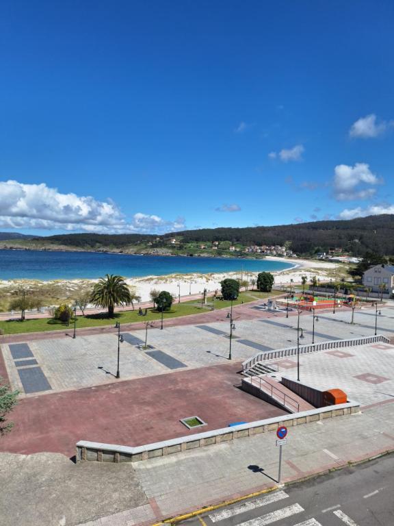 a parking lot with a beach and the ocean at Piso da Playa in Laxe