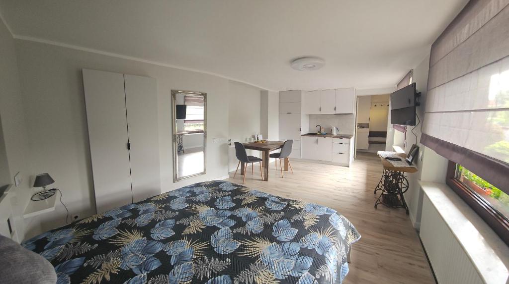 奥尔什丁Apartament Wierzbowa - Pod Orzechem的一间带床的卧室和一间带桌子的厨房