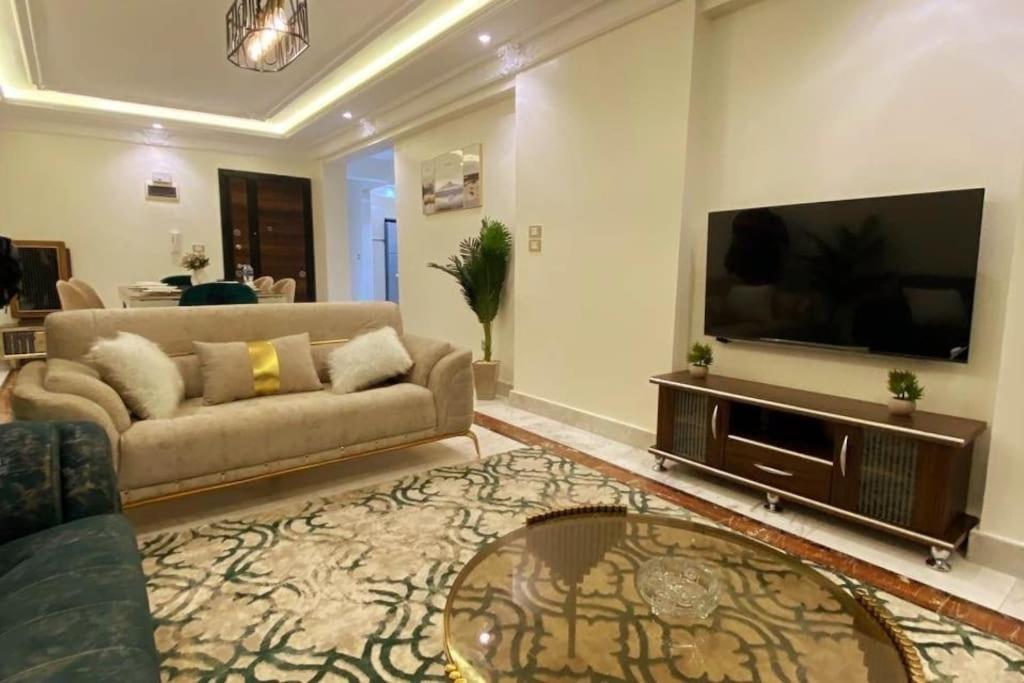 a living room with a couch and a flat screen tv at Luxury 3 bedroom Apartment with a great Seaview* in Abū Qīr