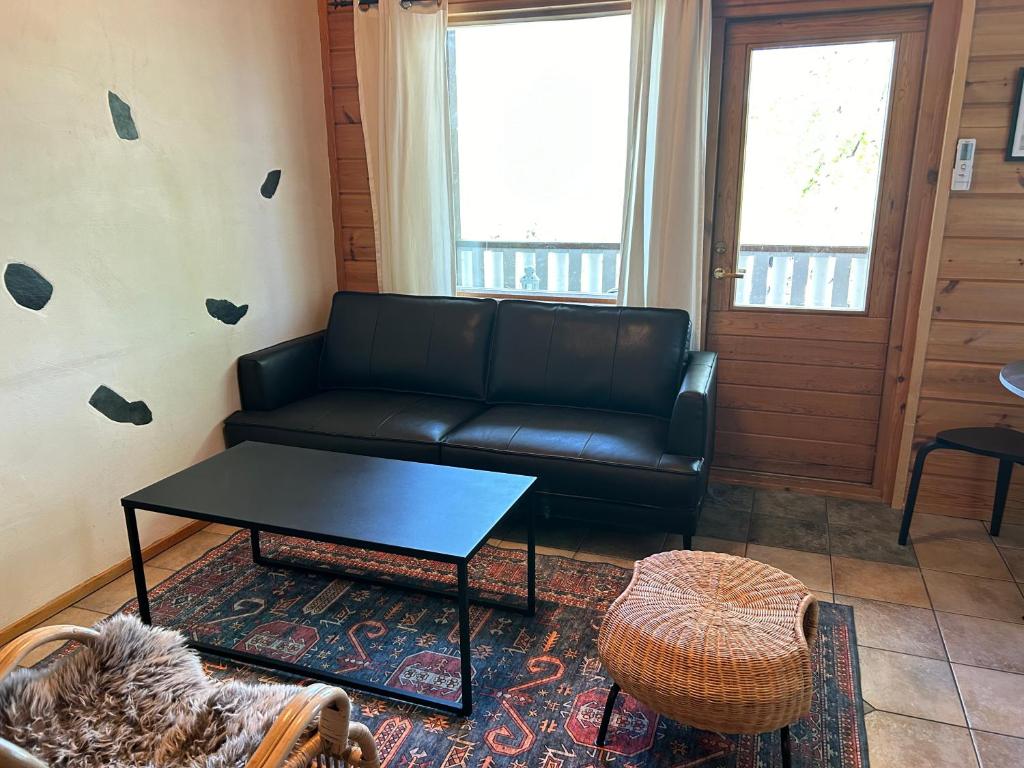 a living room with a black couch and a table at Kodikas loma-asunto Tahkon ytimestä in Tahkovuori