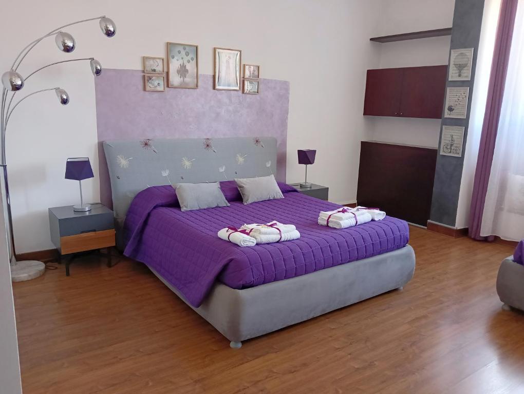 1 dormitorio con 1 cama morada y 2 almohadas en Brà Guest House, en Verona