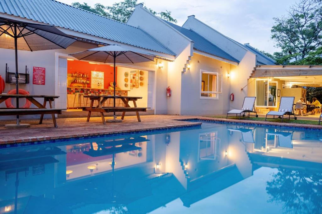 a villa with a swimming pool and a house at PheZulu Guest Lodge in Victoria Falls