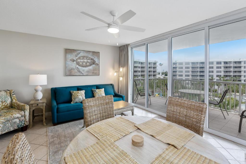 a living room with a blue couch and a table at Destin West Sandpiper Bld 501 Bay side Condo in Fort Walton Beach