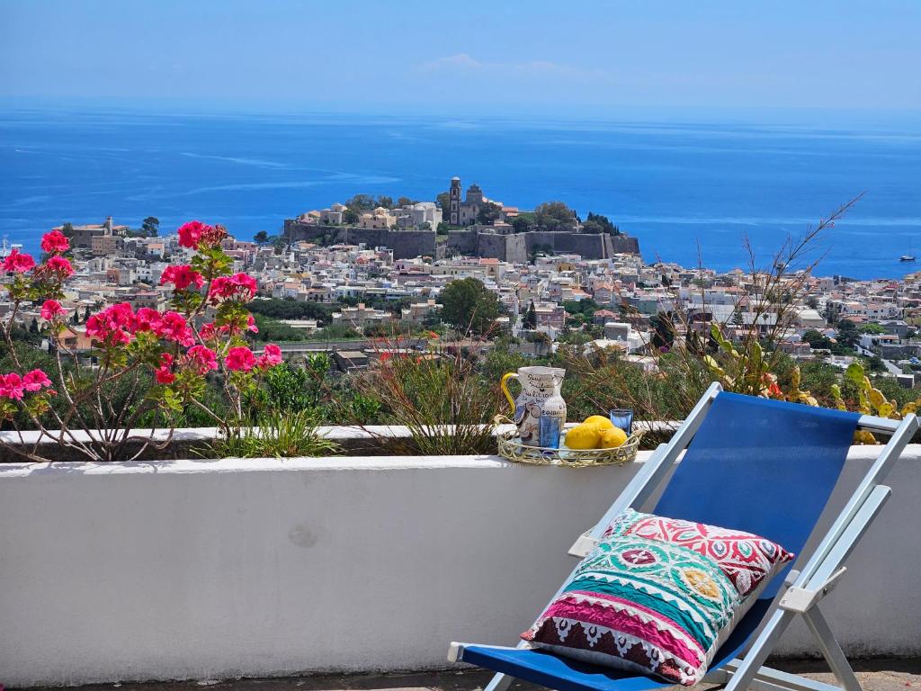 a chair sitting on a ledge with a view of a city at Villa Belvedere in Lipari