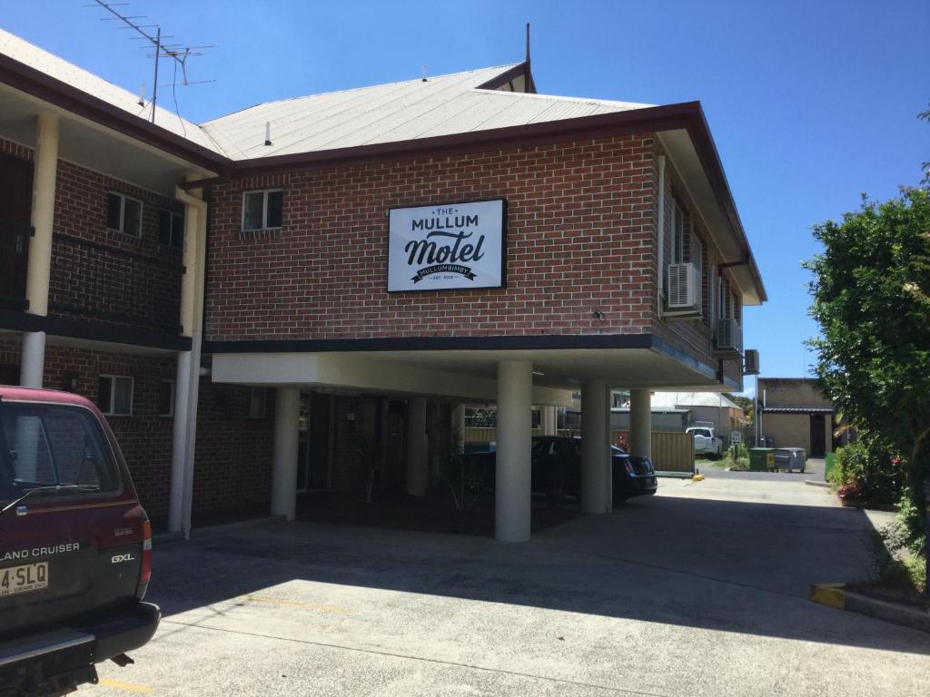 a brick building with a sign for a monday market at The Mullum Motel in Mullumbimby