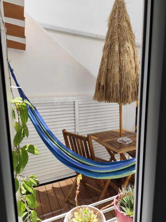 a hammock and a table in a room at Stressfree Apartamento in Vila Nova de Milfontes