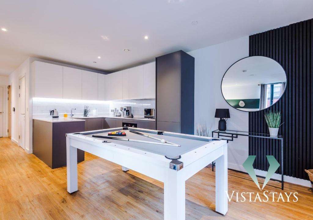 ein Wohnzimmer mit einem Billardtisch und eine Küche in der Unterkunft Modern 2 Bed Apartment with Pool Table by Vista Stays Short Lets Manchester in Manchester