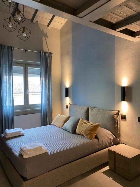 Schlafzimmer mit einem Bett mit blauen Vorhängen und einem Fenster in der Unterkunft Sogni d'artista in Pietrasanta