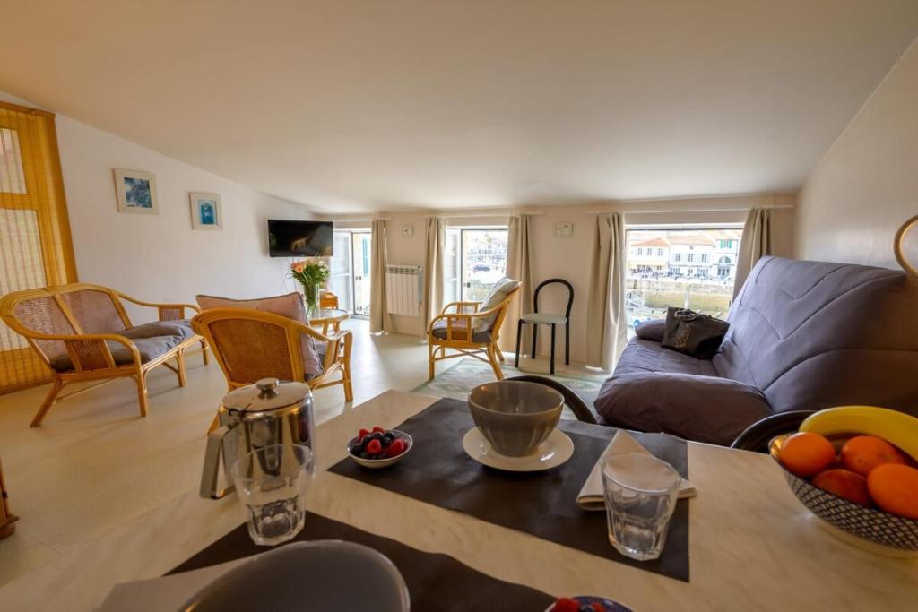 un salon avec un canapé et une table dans l'établissement Apartment with 3 windows overlooking the port of St Martin de Ré, à Saint-Martin-de-Ré