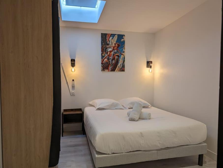 a bedroom with a white bed with a blue ceiling at R'Apparts T3 Industrial Spirit in Grenoble