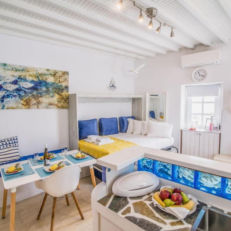 ミコノス・シティにあるLike a white seagull in Mykonos!のベッド1台、テーブル(フルーツ付)が備わる客室です。