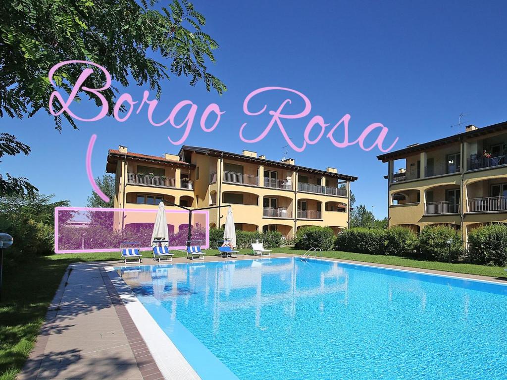 a resort with a swimming pool in front of a building at Sirmione, Borgo Rosa, your holiday flat in Sirmione