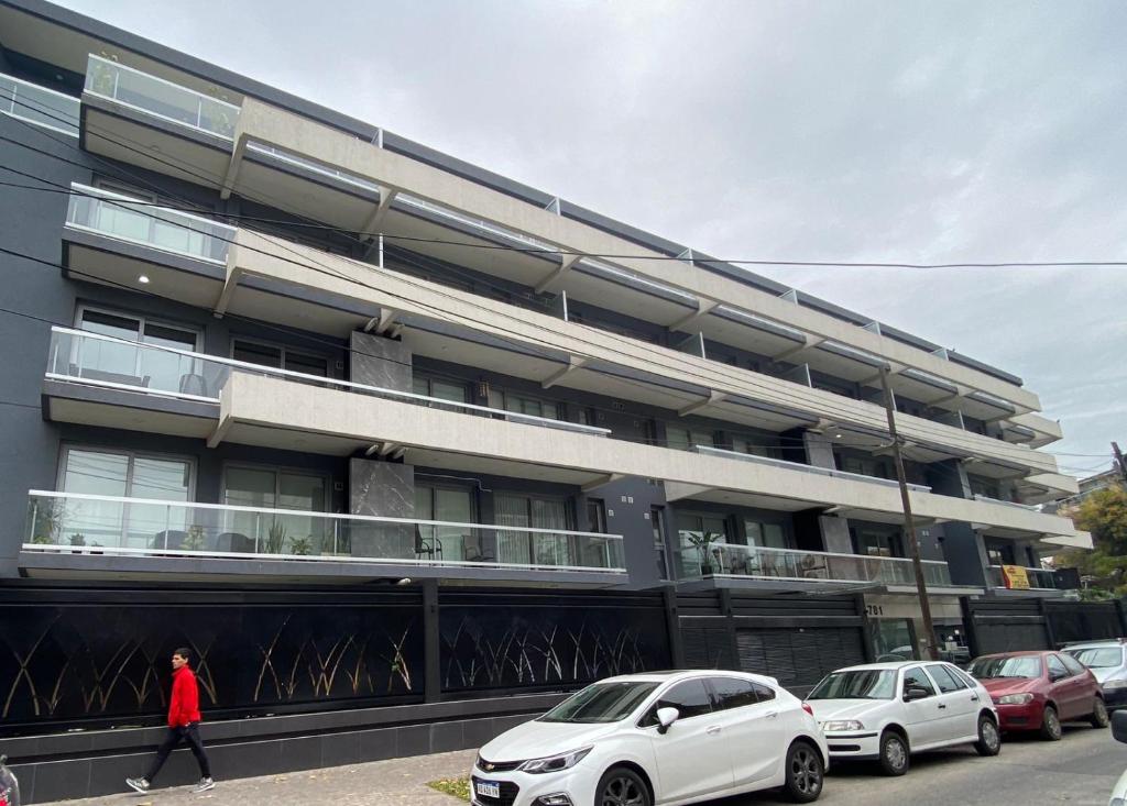 un edificio con coches estacionados frente a él en Adrogué Apartments, zona céntrica de Adrogué en Adrogué