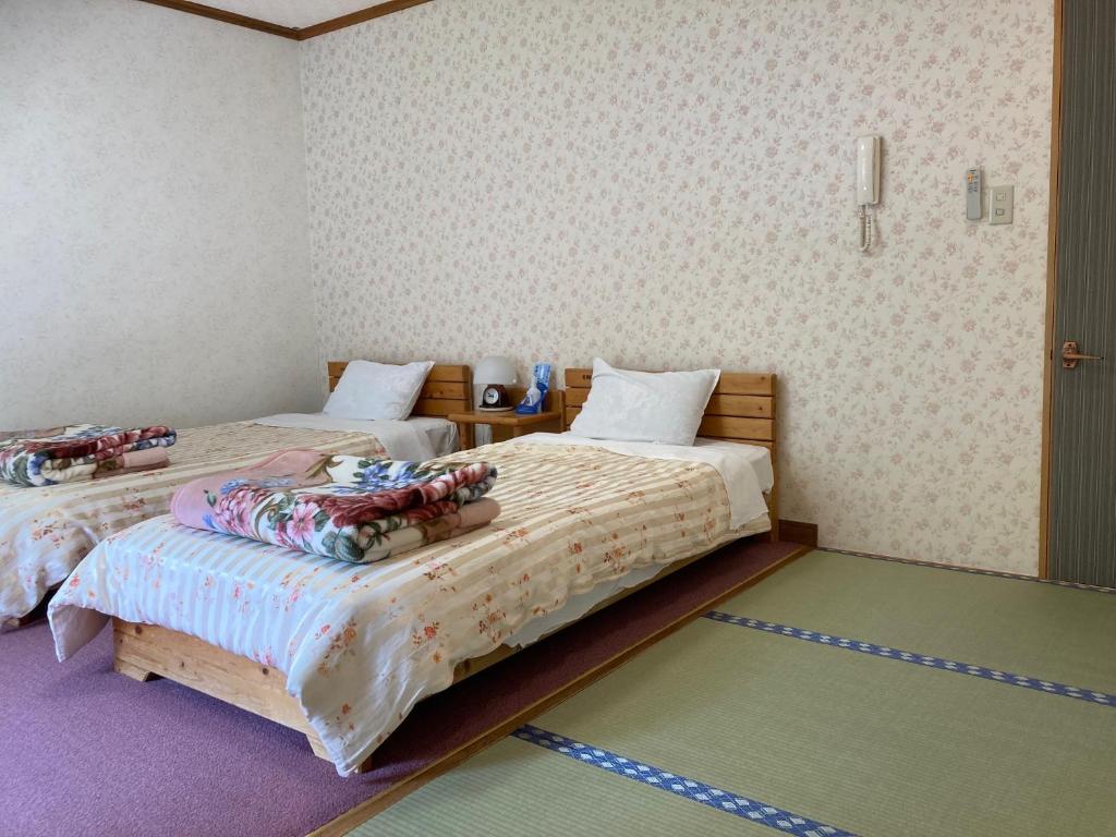 Postel nebo postele na pokoji v ubytování Pension Kaoru