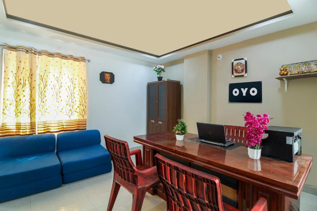- un salon avec une table et un canapé bleu dans l'établissement New Cyber Grand Madhapur, à Kondapur