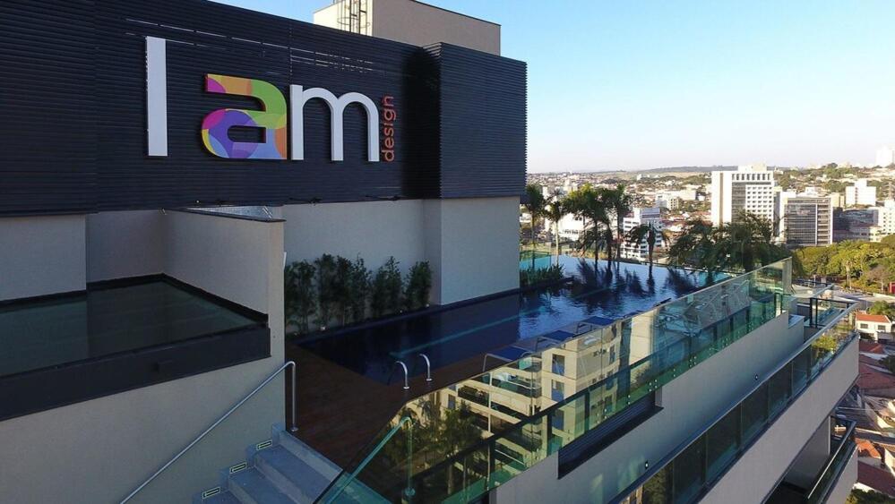 a building with a swimming pool on the side of it at I am Design Hotel Campinas by Hotelaria Brasil in Campinas