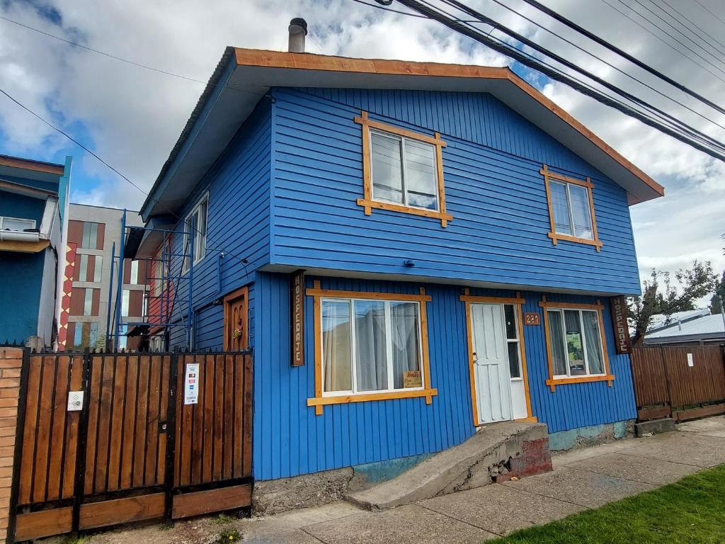 uma casa azul com uma cerca em frente em Pies a tierra em Coihaique