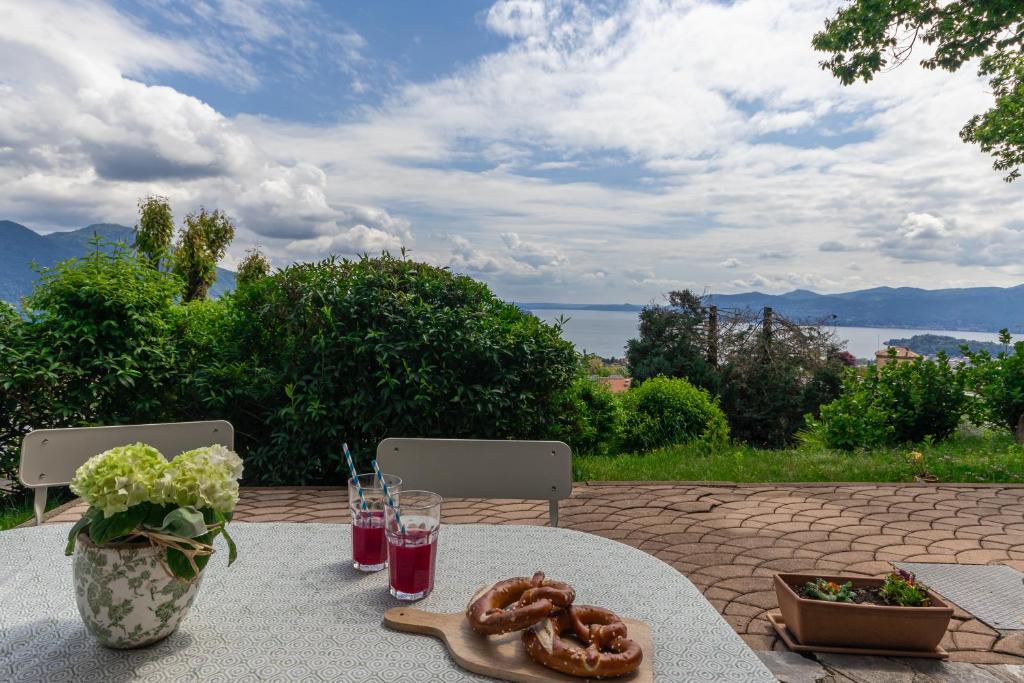 uma mesa com um prato de comida e um vaso de flores em Casamina vista lago Verbania em Arizzano