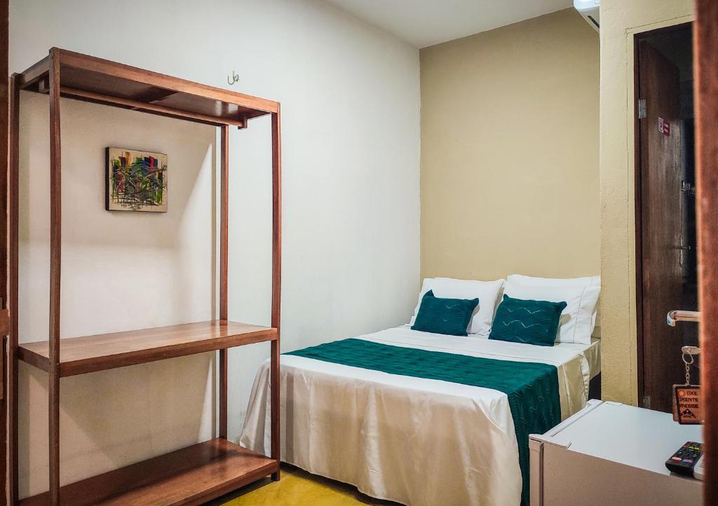 ein kleines Schlafzimmer mit einem Bett mit blauen Kissen in der Unterkunft Casa Mar Self Jeri in Jericoacoara