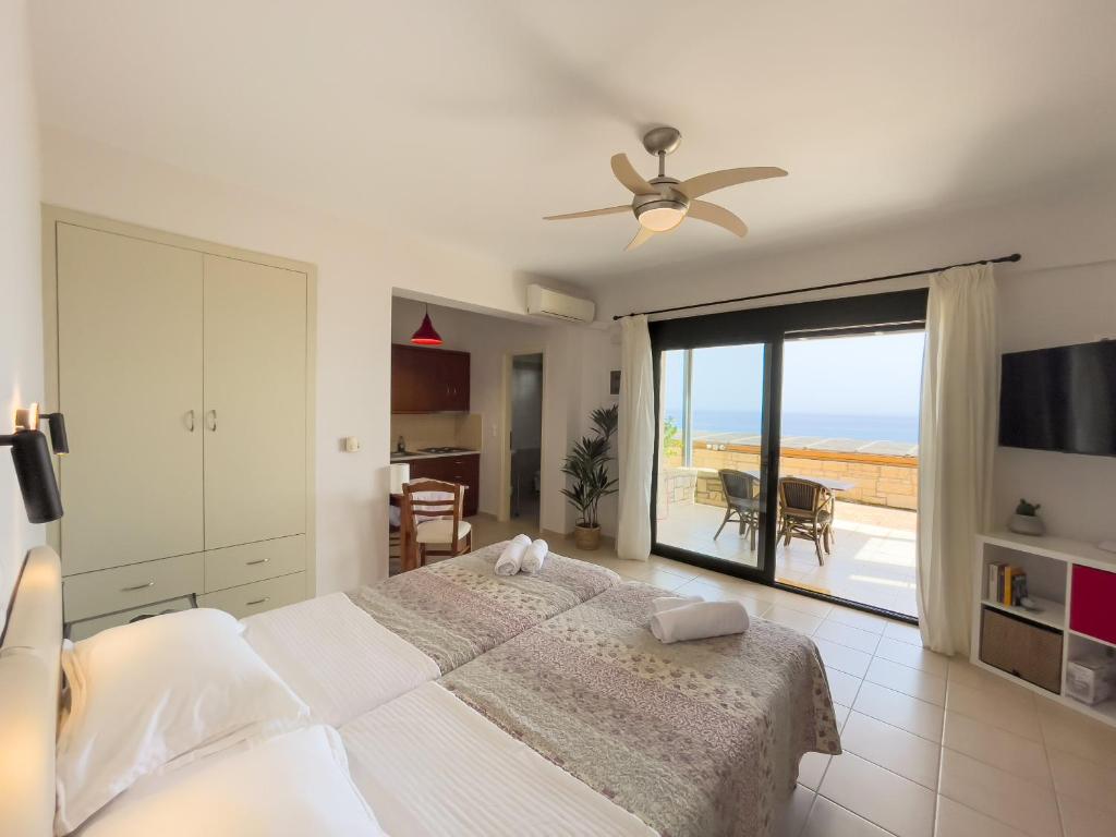 a bedroom with a bed and a view of the ocean at Portela Apartments Kastri in Keratokampos