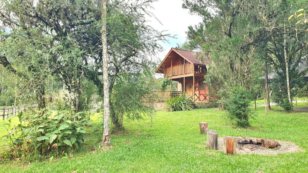 ein Holzhaus mitten auf einem Feld in der Unterkunft Pousada Vale da Imbuia chalé para temporada in Urubici