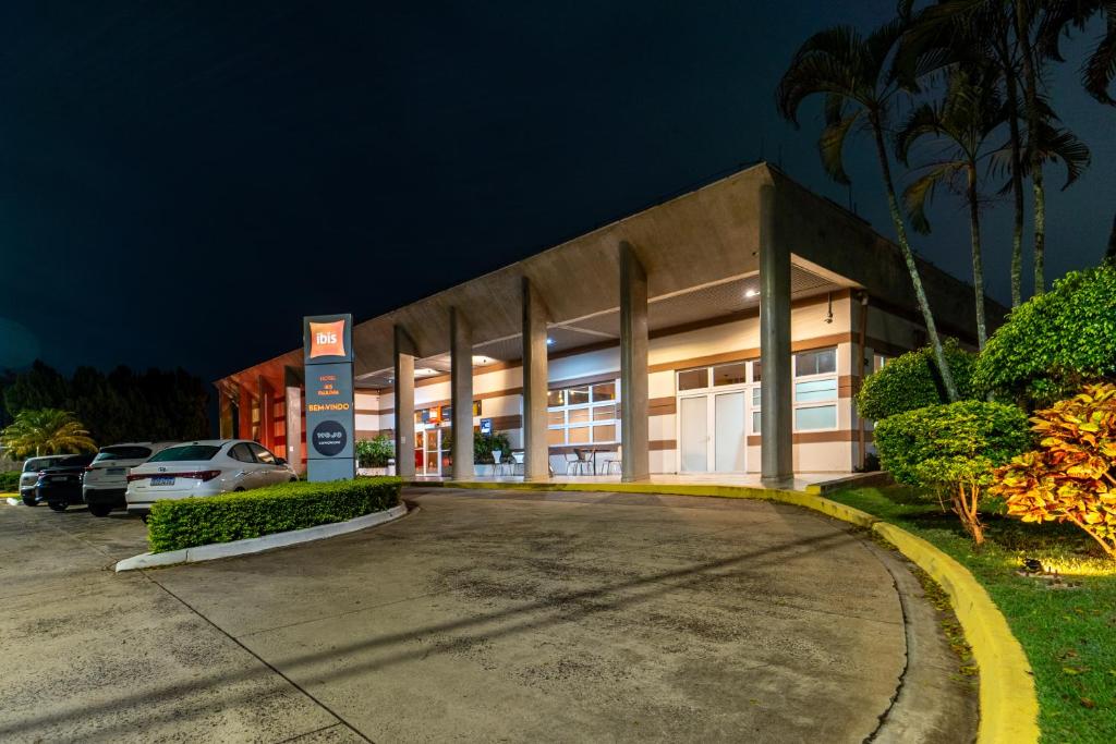 a large building with a parking lot at night at ibis Paulinia in Paulínia