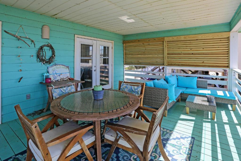 une salle à manger avec une table et des chaises sur une terrasse couverte dans l'établissement Pelican Bend by Pristine Properties Vacation Rentals, à Indian Pass