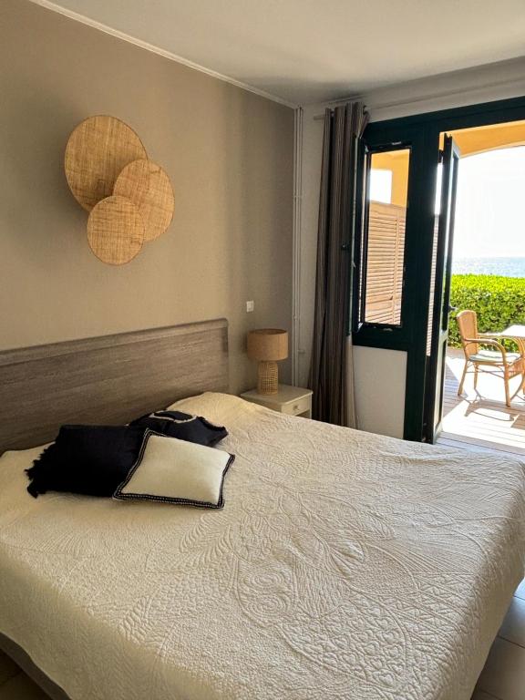 a bedroom with a bed with a view of a patio at Hotel Thalassa in Cargèse