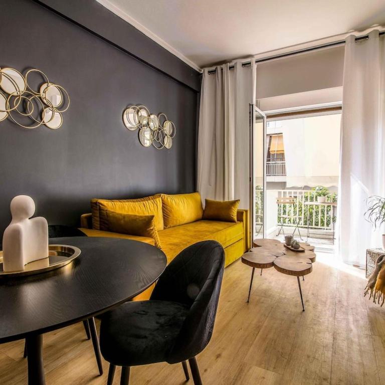 een woonkamer met een gele bank en een tafel bij Classy Apartment in Athens in Athene