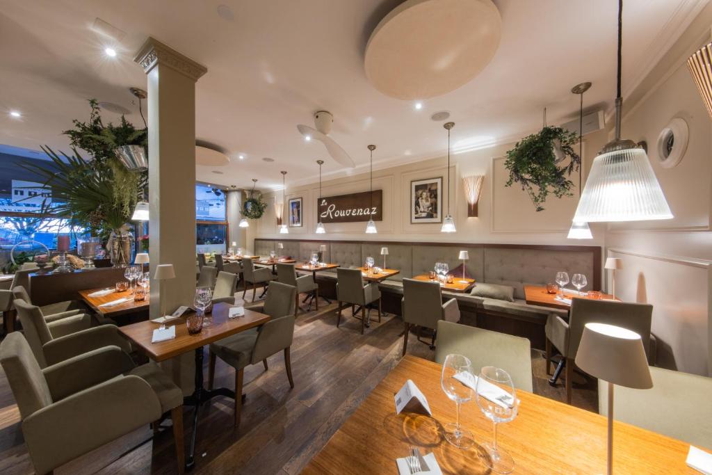 um restaurante com mesas e cadeiras e um bar em La Rouvenaz em Montreux