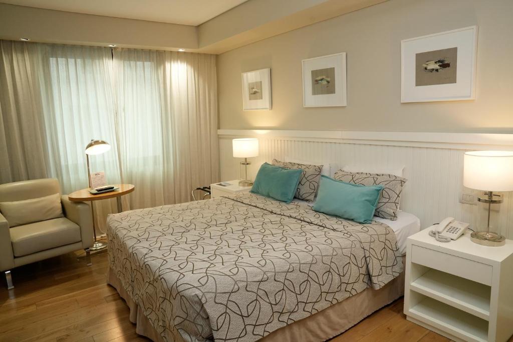 um quarto de hotel com uma cama e uma cadeira em Hotel Metropolitano Supara em Buenos Aires