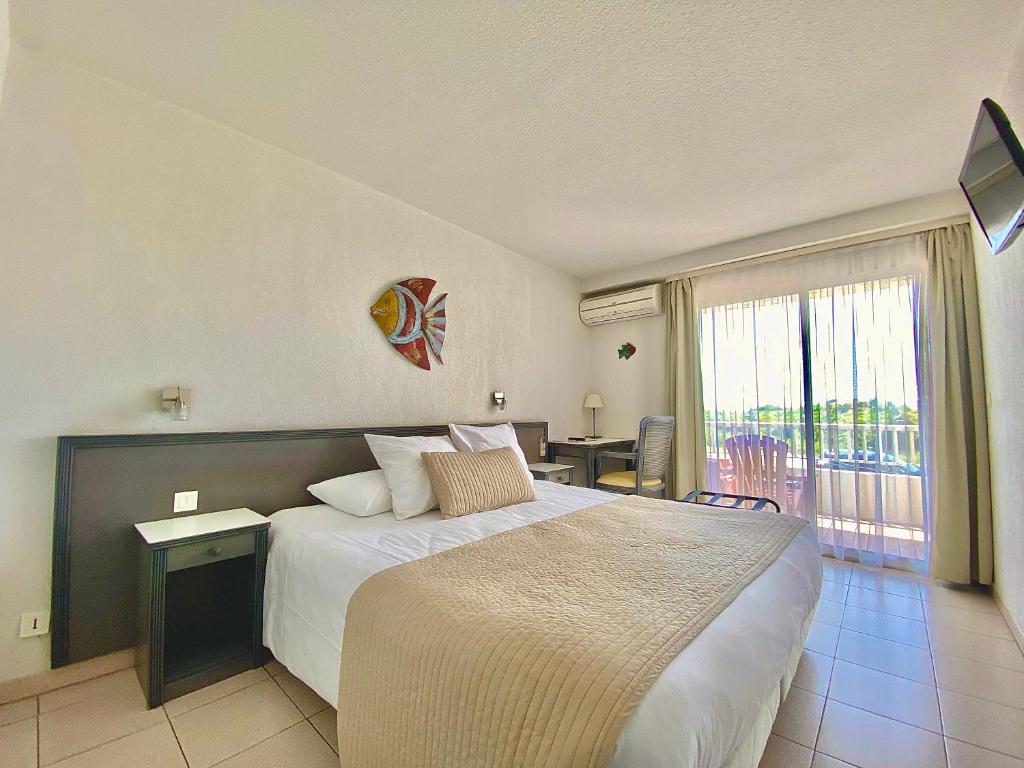 Postel nebo postele na pokoji v ubytování Hôtel Bellevue Cap d'Agde