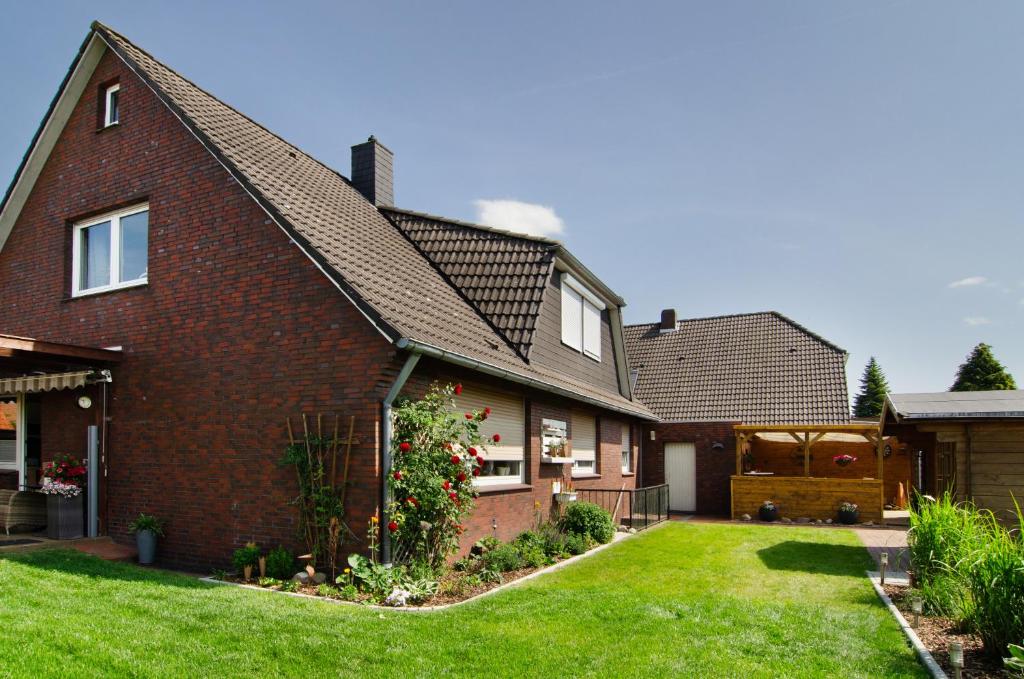 a brick house with a green yard at Ferienwohnung Goesmann in Zetel
