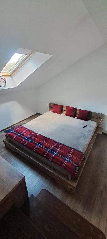 uma cama com almofadas vermelhas num quarto branco em Studio Casa Mia em Câmpulung Moldovenesc