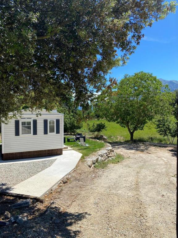 une petite remorque blanche garée à côté d'un chemin de terre dans l'établissement Mobil Home, à Tralonca