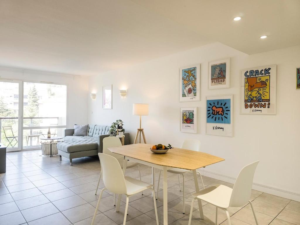 un salon avec une table, des chaises et un canapé dans l'établissement A022 Chic Cannes Flat Balcony Parking, à Cannes