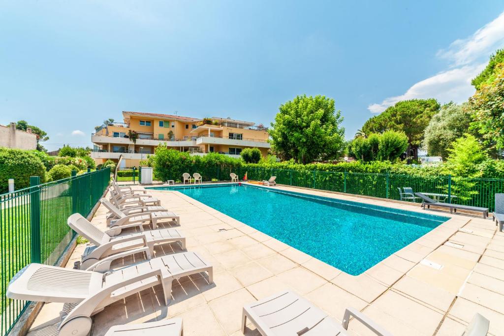 - une piscine avec des chaises longues à côté d'un complexe dans l'établissement Appartement Mandelieu sur les berges de Siagne, à Mandelieu-la-Napoule