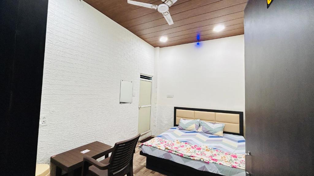 1 dormitorio con 1 cama, 1 mesa y 1 silla en Hotel Amrit shree, en Ujjain