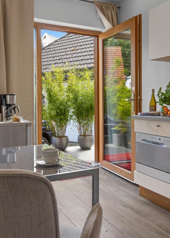 a kitchen with a sliding glass door to a garden at Suiten - Appartement by Studio Living in Haselünne