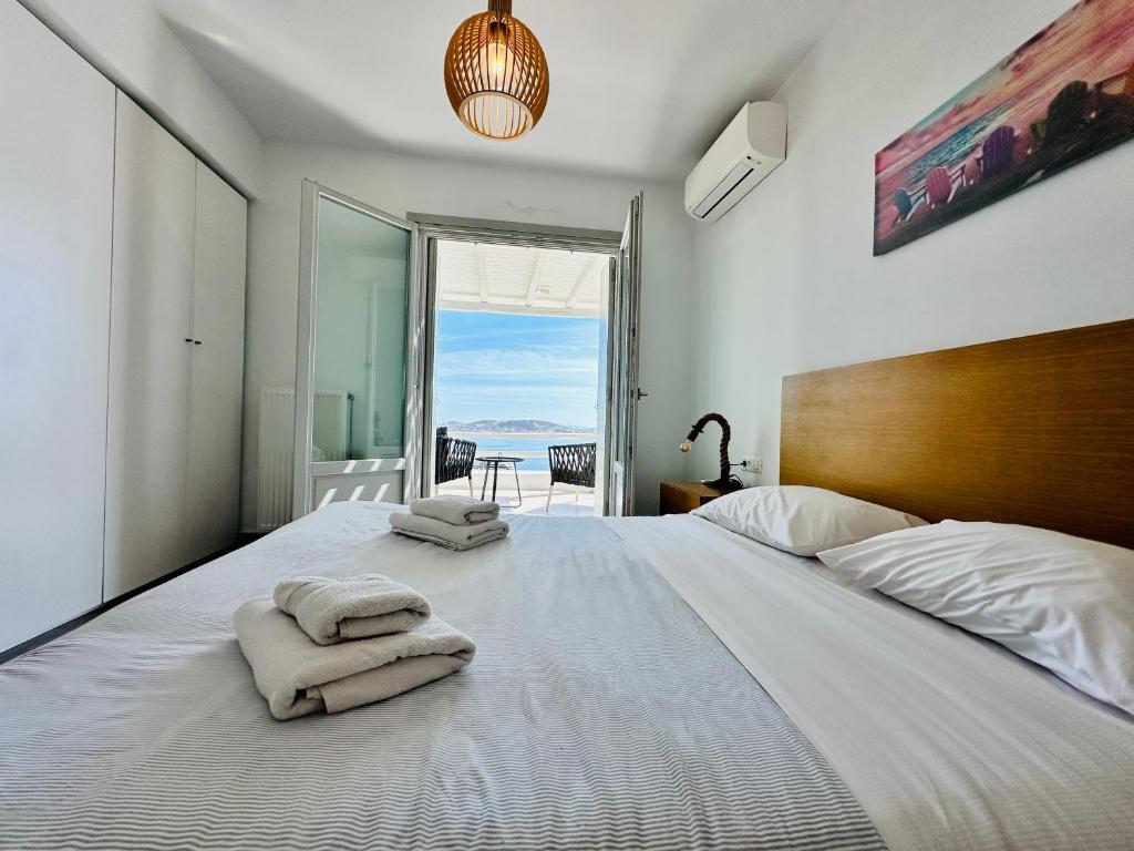a bedroom with a large white bed with towels on it at Seaview & Jacuzzi summer residence in Mýkonos City