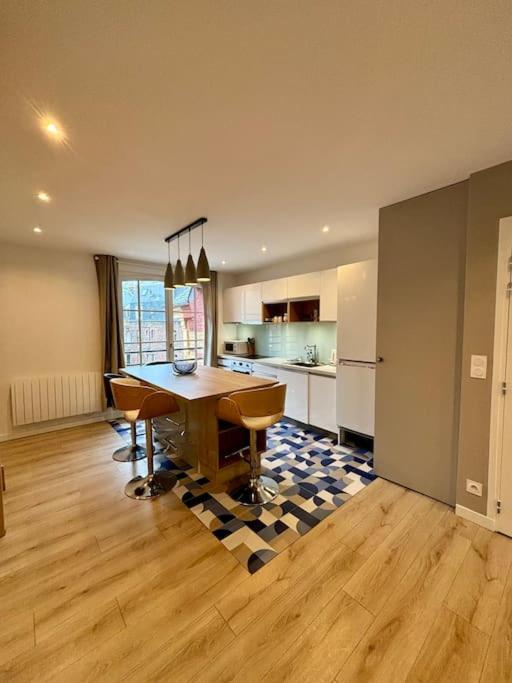 une cuisine avec une table et des chaises dans une pièce dans l'établissement Le petit écolier Hyper-centre Proxi gare-plage, à Dieppe