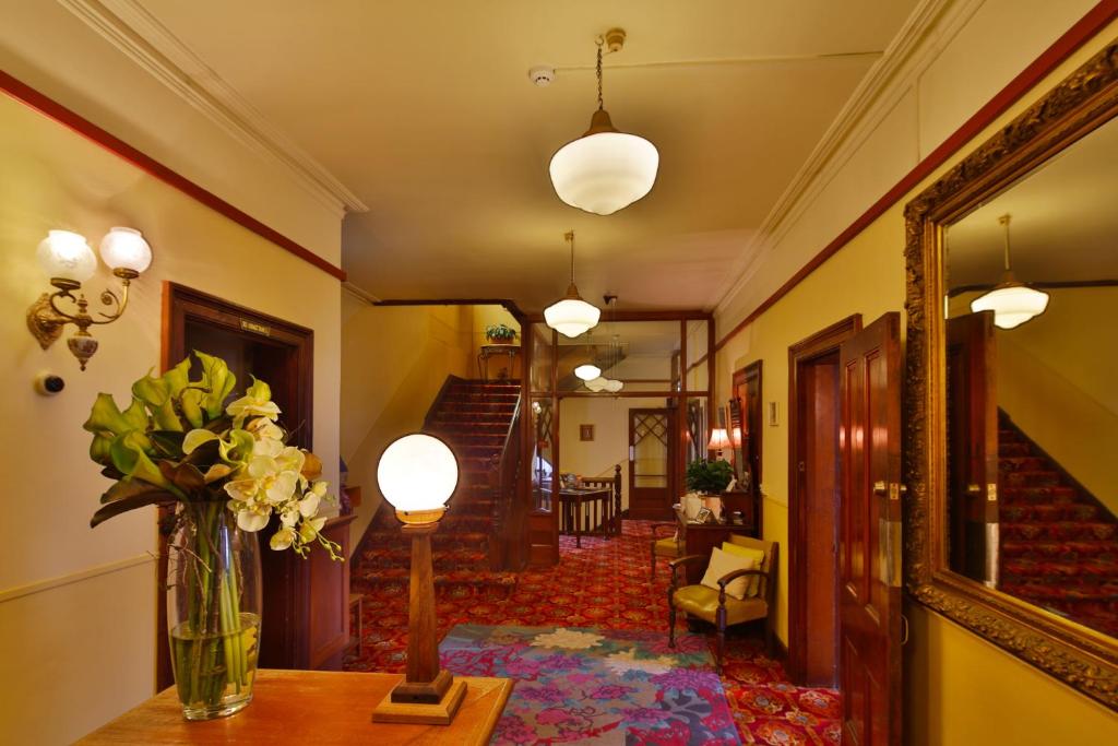 un pasillo con un jarrón de flores sobre una mesa en Astor Private Hotel en Hobart