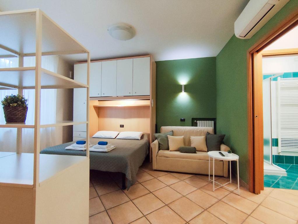 ein Schlafzimmer mit einem Bett und einem Sofa in einem Zimmer in der Unterkunft Nel centro di Desenzano in Desenzano del Garda