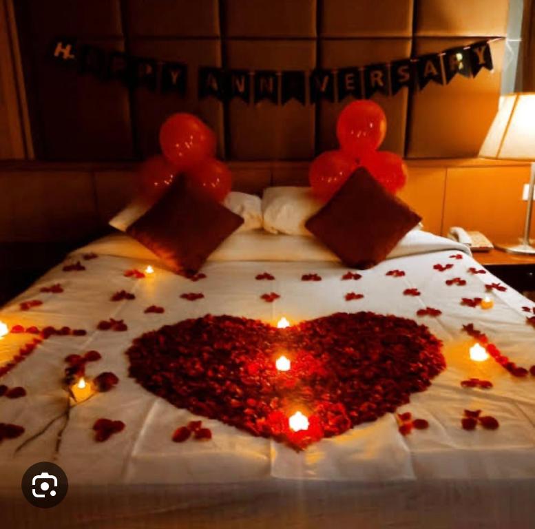 un cœur fait de fleurs sur un lit dans l'établissement Mountain Mist Meadows, à Ooty