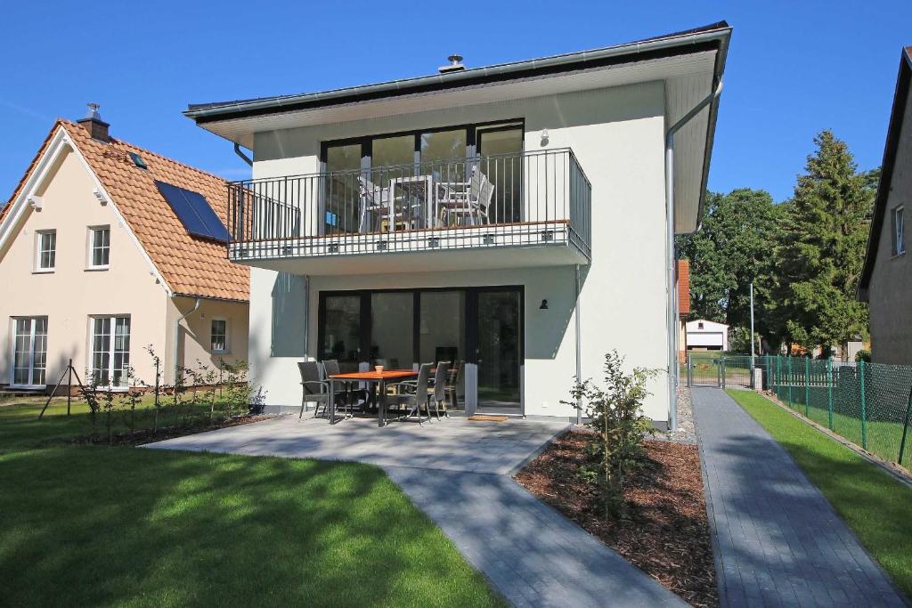 バーベにあるFerienhaus Igelbauのバルコニー(テーブル、椅子付)が備わる家です。