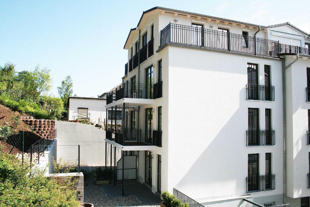 Villa Lena - Whg 09 mit Balkon في اوستيباد سيلين: مبنى أبيض بشرفات سوداء